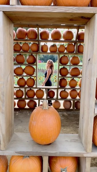 Elona Miftari standing near pumpkins